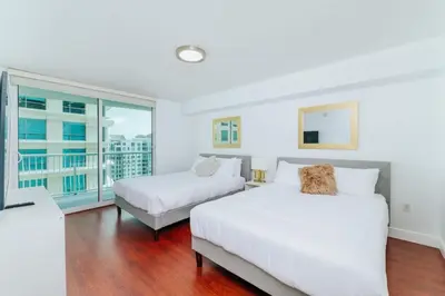 a bedroom with two beds and a balcony at Lovely 2BR Rental in the Heart of Brickell in Miami