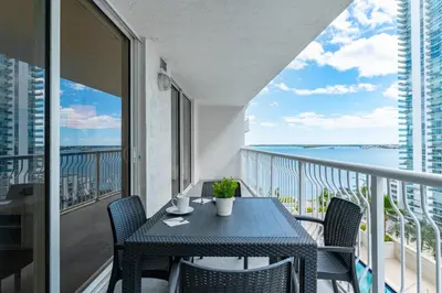 a table and chairs on a balcony with a view of the ocean at 2bedroom ocean views brickell free parking in Miami