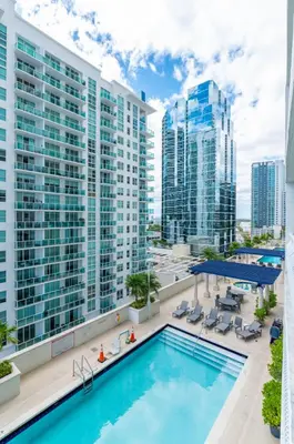 a swimming pool on top of a building with tall buildings at 2bedroom ocean views brickell free parking in Miami