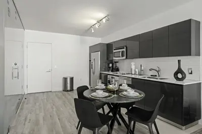 a black and white kitchen with a table and chairs at Luxurious 2Bedroom Apt Parking in Brickell. in Miami