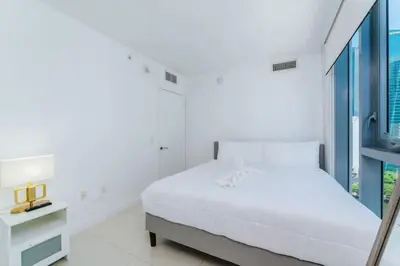 a white bedroom with a bed and a window at Exclusive, Amazing, Bright and Spacious at Brickell in Miami