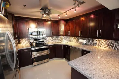a kitchen with wooden cabinets and a stove top oven at Alexander14192 in Miami Beach