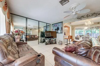 a living room with leather furniture and a flat screen tv at 4 Mi to Hard Rock Stadium Miramar Home with BBQ! in Miramar