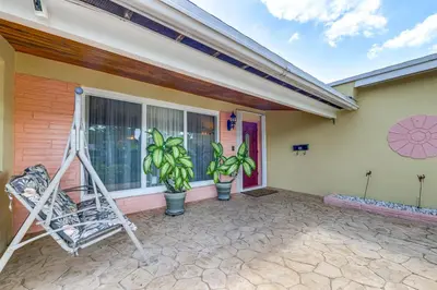 a porch of a house with plants and a ladder at 4 Mi to Hard Rock Stadium Miramar Home with BBQ! in Miramar