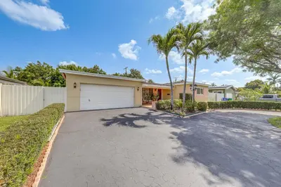 a house with a driveway with a garage at 4 Mi to Hard Rock Stadium Miramar Home with BBQ! in Miramar