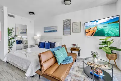 a bedroom with a bed and a couch and a table at Sunset Waterview Oasis Studio in Miami
