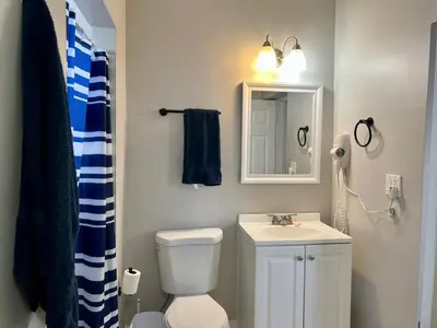 a bathroom with a toilet and a sink and a mirror at Coral Gable 3BR House in Miami