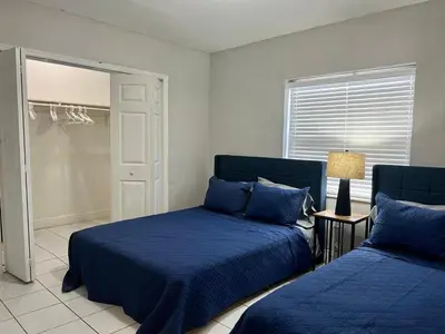 a bedroom with two beds with blue pillows at Coral Gable 3BR House in Miami