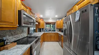 a kitchen with wooden cabinets and a stainless steel refrigerator at Private Entrance King Room and Private Bath UMiami in Miami