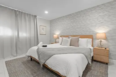 a bedroom with a large bed with white sheets and pillows at 6BR 3BA Heated Pool Miami Vacation in Miami