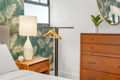 a bedroom with a bed with a lamp and a dresser at The Firefly in Miami Beach