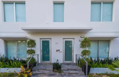 a white house with green doors and stairs at Agave on the Beach in Miami Beach