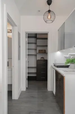 a kitchen with white walls and a hallway with a sink at Agave on the Beach in Miami Beach
