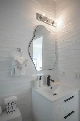 a white bathroom with a sink and a mirror at Agave on the Beach in Miami Beach