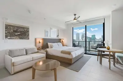 a bedroom with a bed and a couch and a table at Bellini Breeze - Cozy Central Miami Pool and Gym in Miami