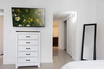 a bedroom with a dresser with a tv on a wall at Beachfront 1 BR Apartment with Kitchen- Sian in Hollywood