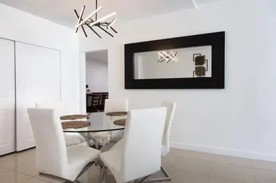 a dining room with a glass table and white chairs at Beachfront 1 BR Apartment with Kitchen- Sian in Hollywood