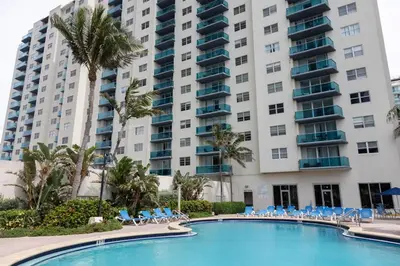 a pool in front of a large apartment building at Beachfront 2 BR Apartment full Kitchen- Sian in Hollywood