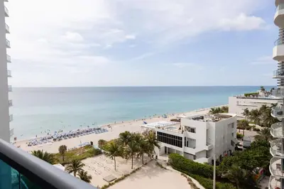 a view of the beach from the balcony of a resort at Beachfront 2 BR Apartment full Kitchen- Sian in Hollywood