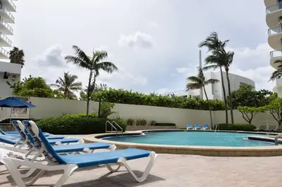 a swimming pool with lounge chairs in a resort at Beachfront 2 BR Apartment full Kitchen- Sian in Hollywood