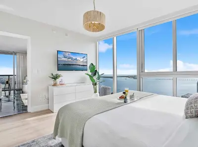 a white bedroom with a large bed and large windows at MVR-Relax in Style Above Brickell in Miami