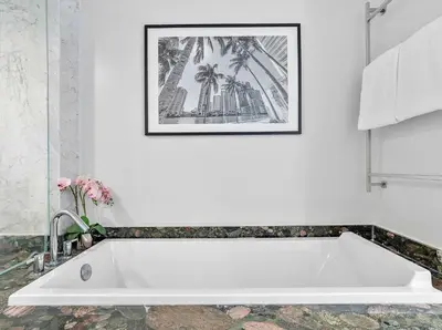 a white bath tub in a bathroom with a picture on the wall at MVR-Relax in Style Above Brickell in Miami