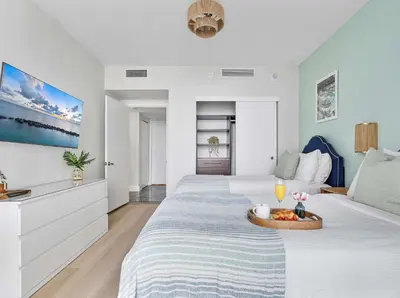 a bedroom with two beds with a tray of fruit on it at MVR-Relax in Style Above Brickell in Miami