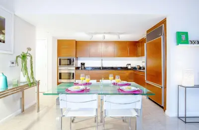 a kitchen with a glass table with chairs and drinks at MVR-Icon Brickell High-Rise w Balcony in Miami