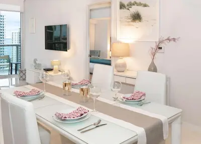 a white dining room with a table and chairs at MVR-Designer Stay in Heart of Brickell in Miami