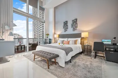a bedroom with a large bed and a desk with a computer at MVR-Water Views & Modern Luxury in Miami