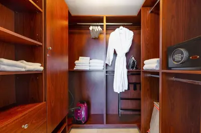 a closet with wooden cabinets and a white robe at MVR - Floor 45 Views & Spa Bliss in Miami