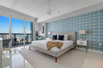 a bedroom with a large bed with a blue accent wall at MVR - Luxury Vibes Above the City in Miami