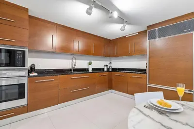 a kitchen with wooden cabinets and a plate of food on a table at MVR - Luxury Vibes Above the City in Miami
