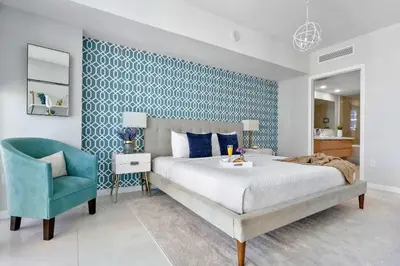 a bedroom with a bed and a blue accent wall at MVR - Luxury Vibes Above the City in Miami