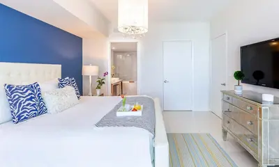 a bedroom with a bed and a dresser with a tv at MVR - Stylish Stay w Resort Access in Miami