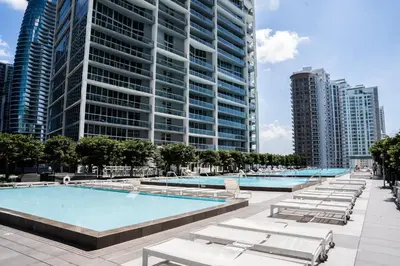 a large swimming pool with lounge chairs and tall buildings at MVR - Magnificent Bay & River Views SPA Balcony in Miami