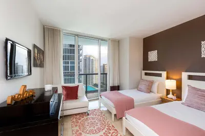 a hotel room with a bedroom with a bed and a tv at MVR - Brickell Icon w Massive Pool & Spa in Miami