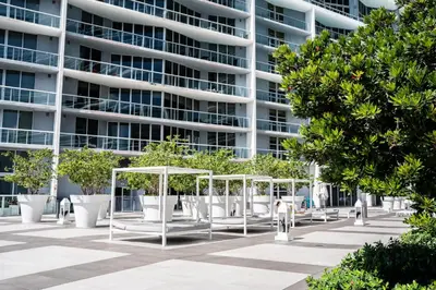 a building with trees and benches in front of it at MVR - Designer Condo in Prime Brickell in Miami