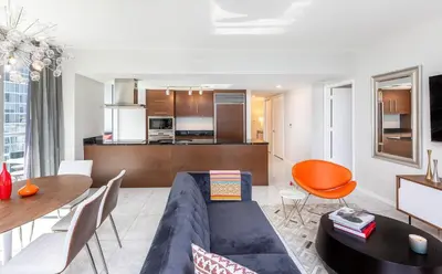 a living room with a blue couch and a table at MVR - The Ultimate Brickell Balcony in Miami
