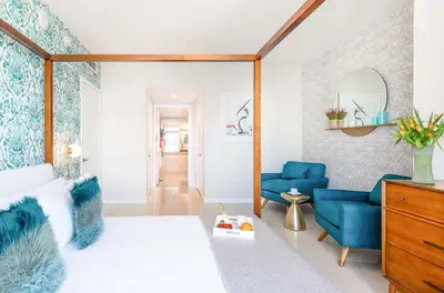 a living room with blue chairs and a bed at MVR - Wake to Water & Skyline Views in Miami