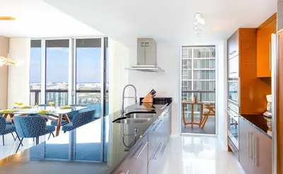 a kitchen with a sink and a table with chairs at MVR - Wake to Water & Skyline Views in Miami