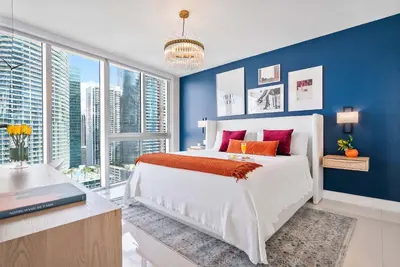 a bedroom with blue walls and a bed with red pillows at MVR - Icon Brickell Beauty with Views in Miami