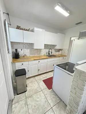 a kitchen with white cabinets and a sink at Miami Casa in Miami Gardens