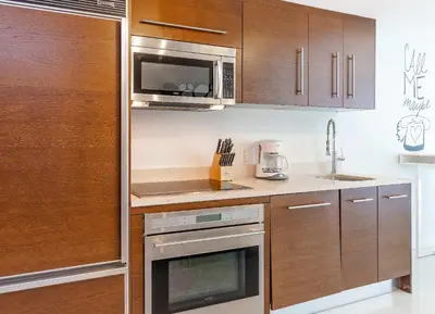 a kitchen with wooden cabinets and a microwave at MVR - Stylish Escape in Icon Brickell in Miami