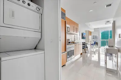 a kitchen with a white refrigerator and a dining room at MVR Sleek Condo with Iconic Views in Miami