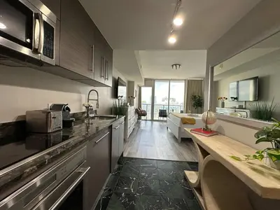 a kitchen with a counter and a living room at MVR - Live the Icon Brickell Dream in Miami