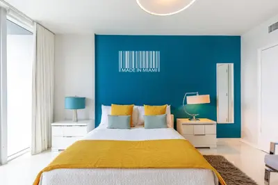 a bedroom with a large bed with a yellow blanket at MVR - Luxury Stay with Spa & Views in Miami
