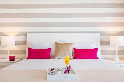 a bed with pink pillows and a tray with a drink on it at MVR - Best Views in Brickell in Miami