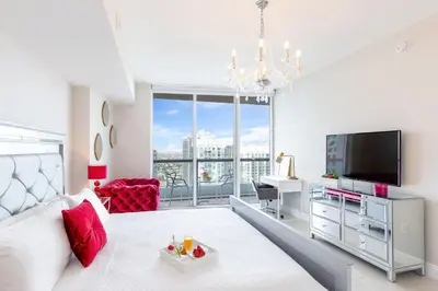 a living room with a bed and a flat screen tv at MVR Bright & Airy Condo with Views in Miami