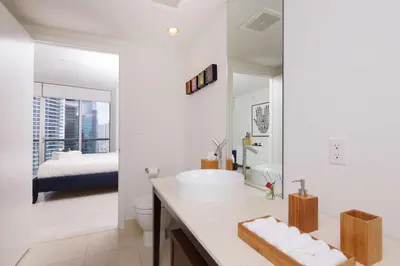 a white bathroom with a sink and a bed at MVR Luxury Condo High Floor European Design in Miami